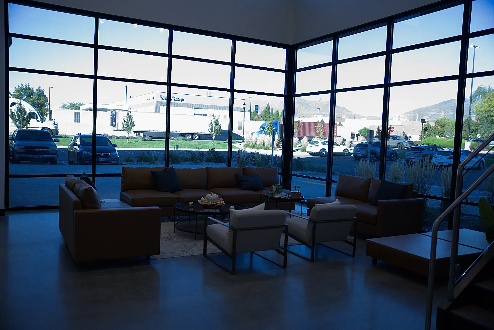 Low sofas along a floor-to-ceiling glass wall at the showroom entrance