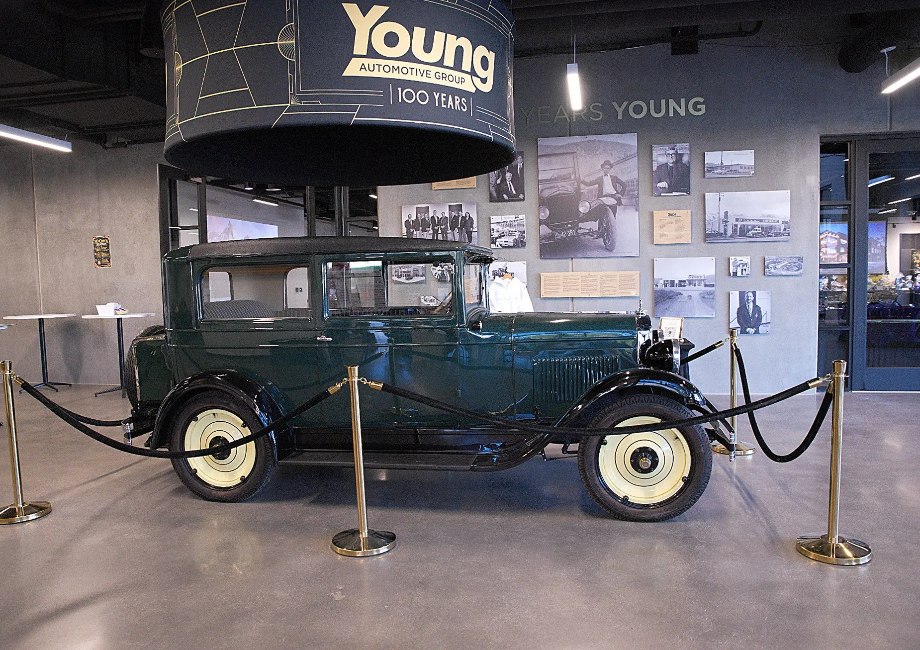 A 1920s Young Motor truck roped off on the showroom floor beneath the hundred-years sign