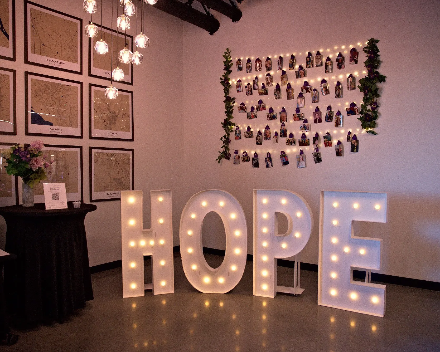 HOPE marquee letters glowing under a wall of pinned family photographs