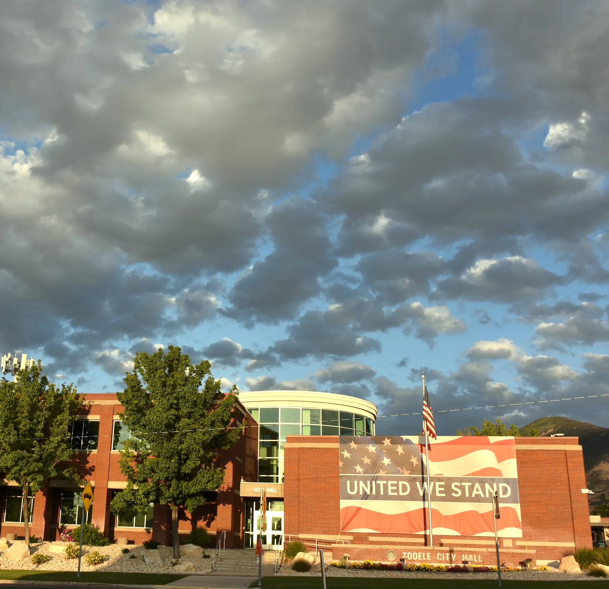 Brick school building with flags under a dramatic cloud bank